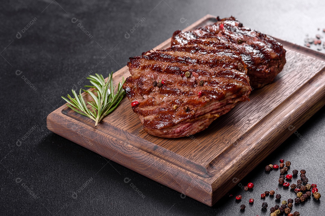 Bife fresco, suculento e delicioso em um fundo escuro. Prato de carne com especiarias e ervas