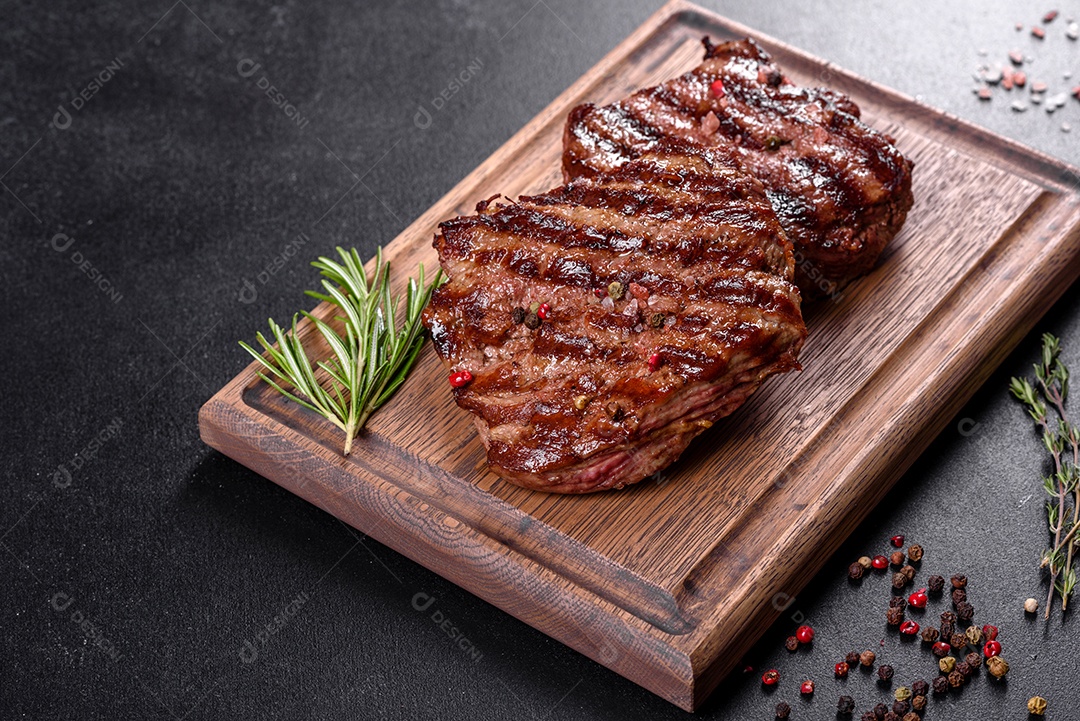 Bife fresco, suculento e delicioso em um fundo escuro. Prato de carne com especiarias e ervas