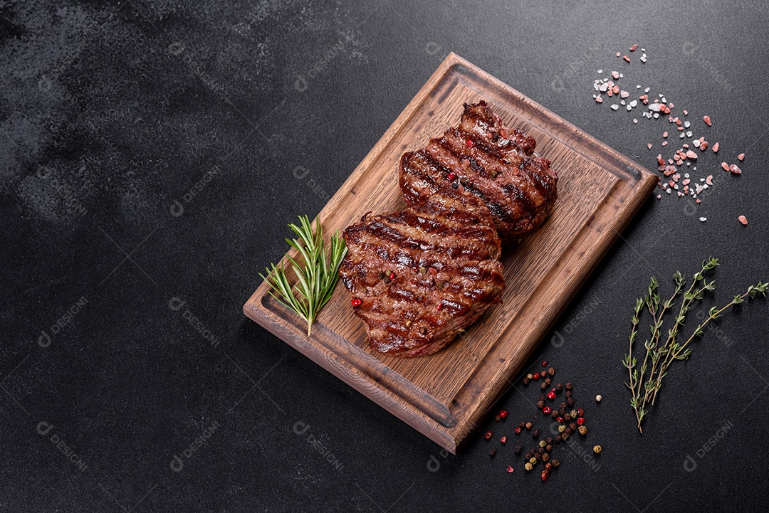 Bife fresco, suculento e delicioso em um fundo escuro. Prato de carne com especiarias e ervas