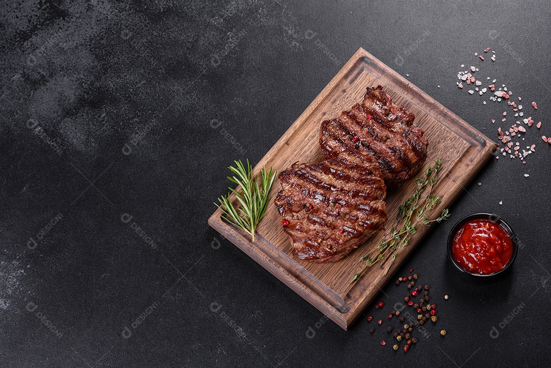Bife fresco, suculento e delicioso em um fundo escuro. Prato de carne com especiarias e ervas
