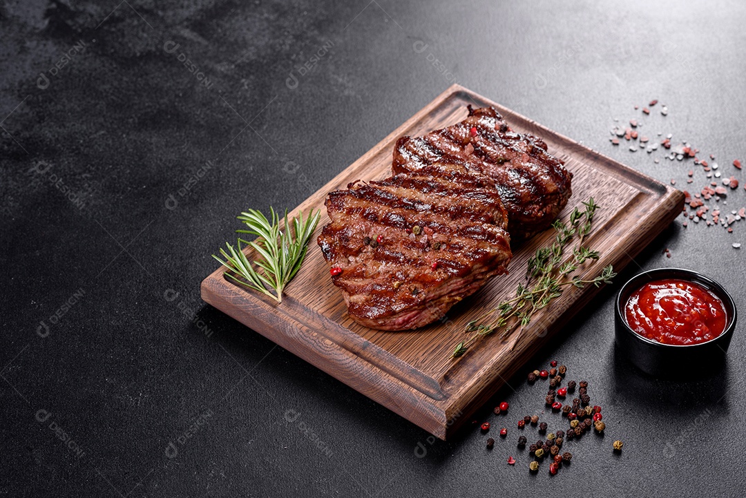 Bife fresco, suculento e delicioso em um fundo escuro. Prato de carne com especiarias e ervas