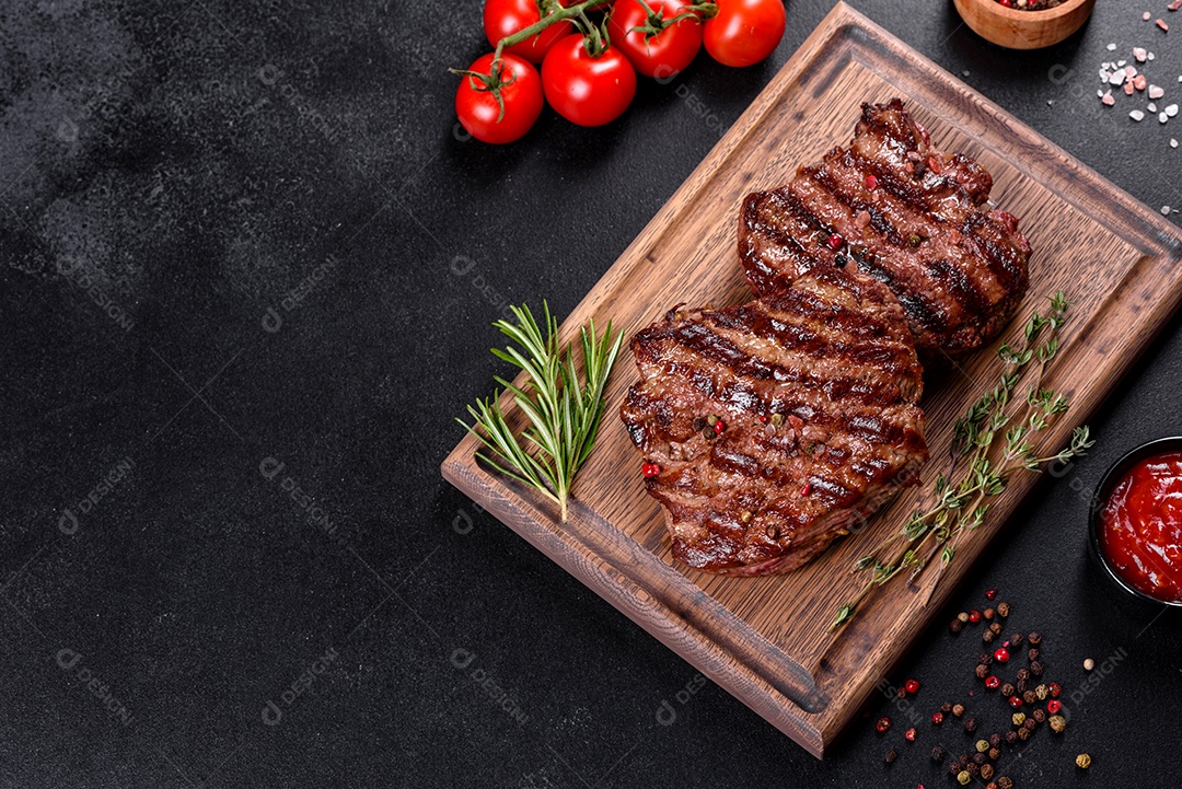 Bife fresco, suculento e delicioso em um fundo escuro. Prato de carne com especiarias e ervas