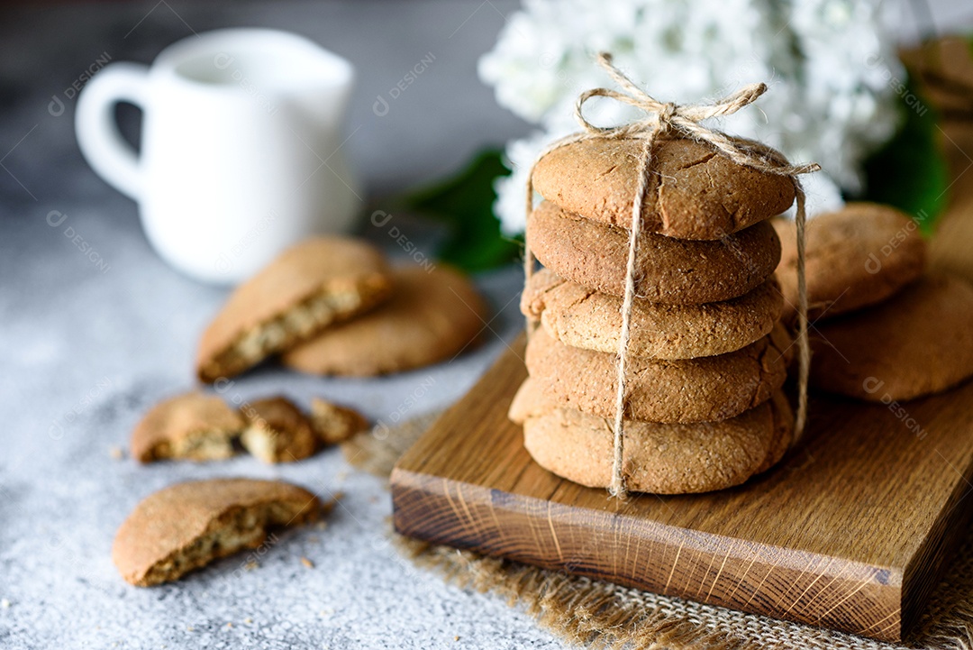 Biscoitos de aveia caseiros em uma tábua de madeira no fundo da mesa velha. Conceito de lanche de comida saudável