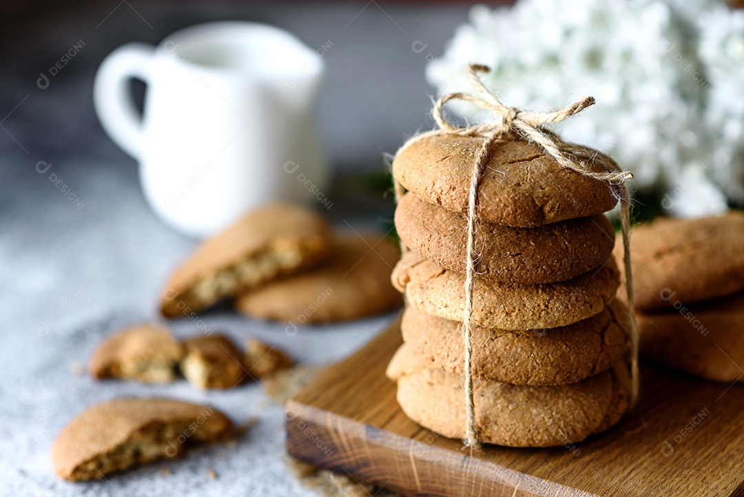 Biscoitos de aveia caseiros em uma tábua de madeira no fundo da mesa velha. Conceito de lanche de comida saudável