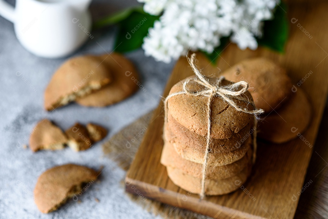 Biscoitos de aveia caseiros em uma tábua de madeira no fundo da mesa velha. Conceito de lanche de comida saudável