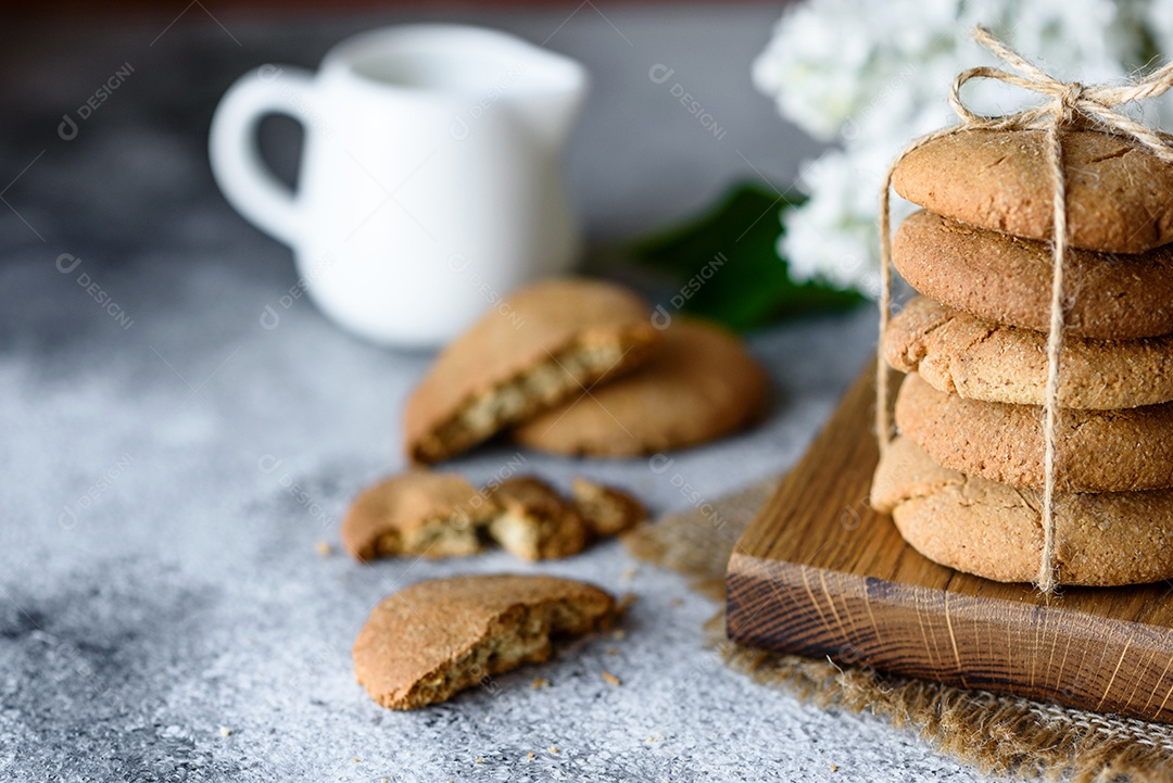 Biscoitos de aveia caseiros em uma tábua de madeira no fundo da mesa velha. Conceito de lanche de comida saudável