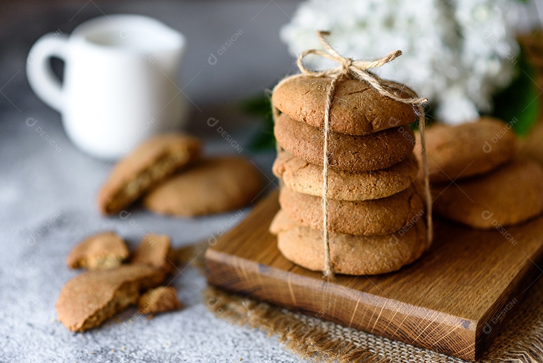 Biscoitos de aveia caseiros em uma tábua de madeira no fundo da mesa velha. Conceito de lanche de comida saudável