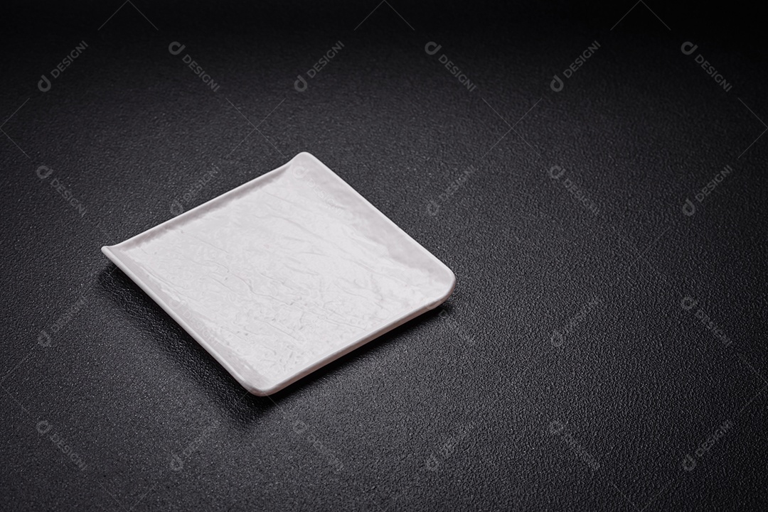 Placa cerâmica quadrada vazia em fundo de concreto texturizado. Utensílio de cozinha