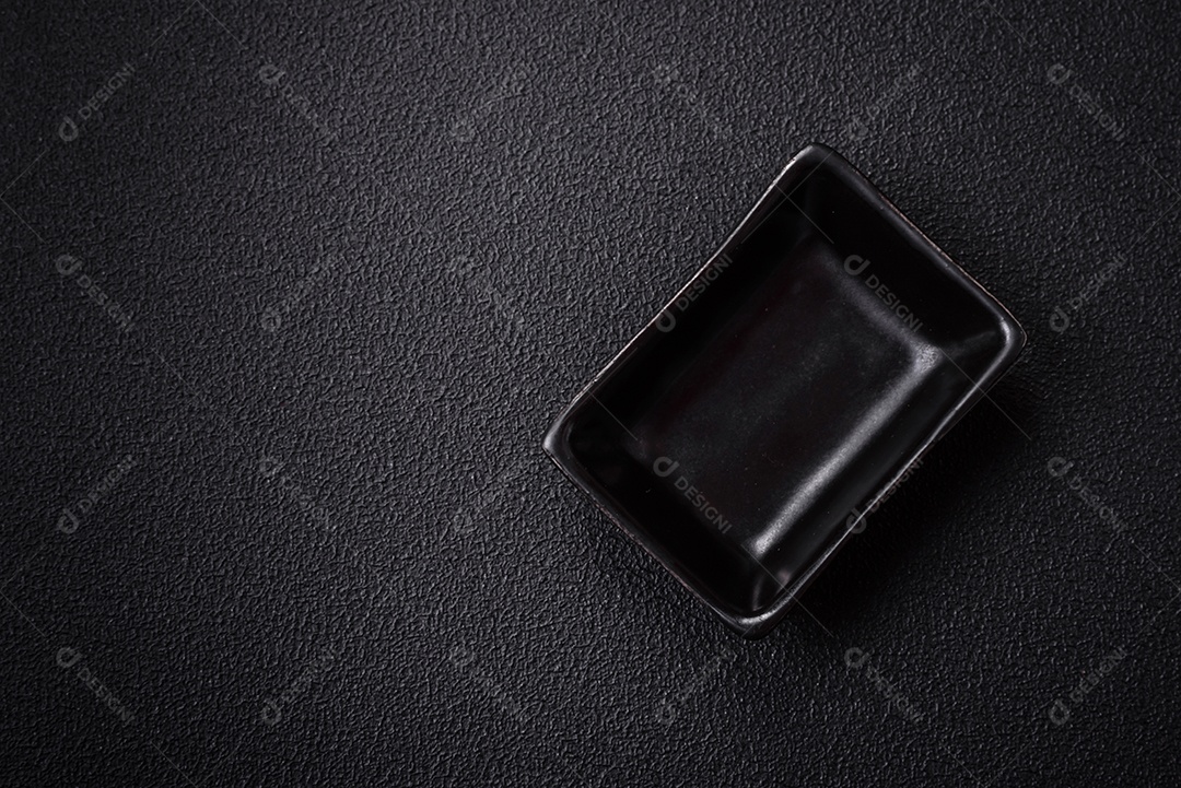 Linda molheira de cerâmica preta vazia em um fundo de concreto texturizado. Utensílio de cozinha