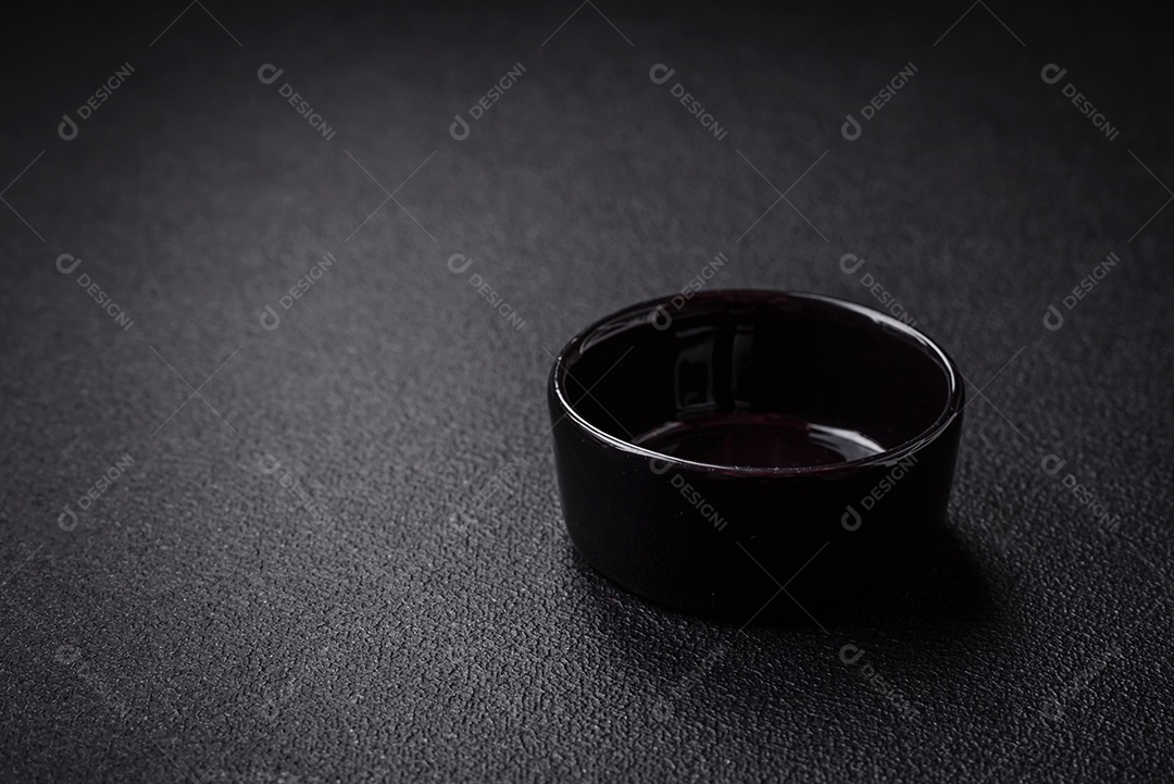 Linda molheira de cerâmica preta vazia em um fundo de concreto texturizado. Utensílio de cozinha