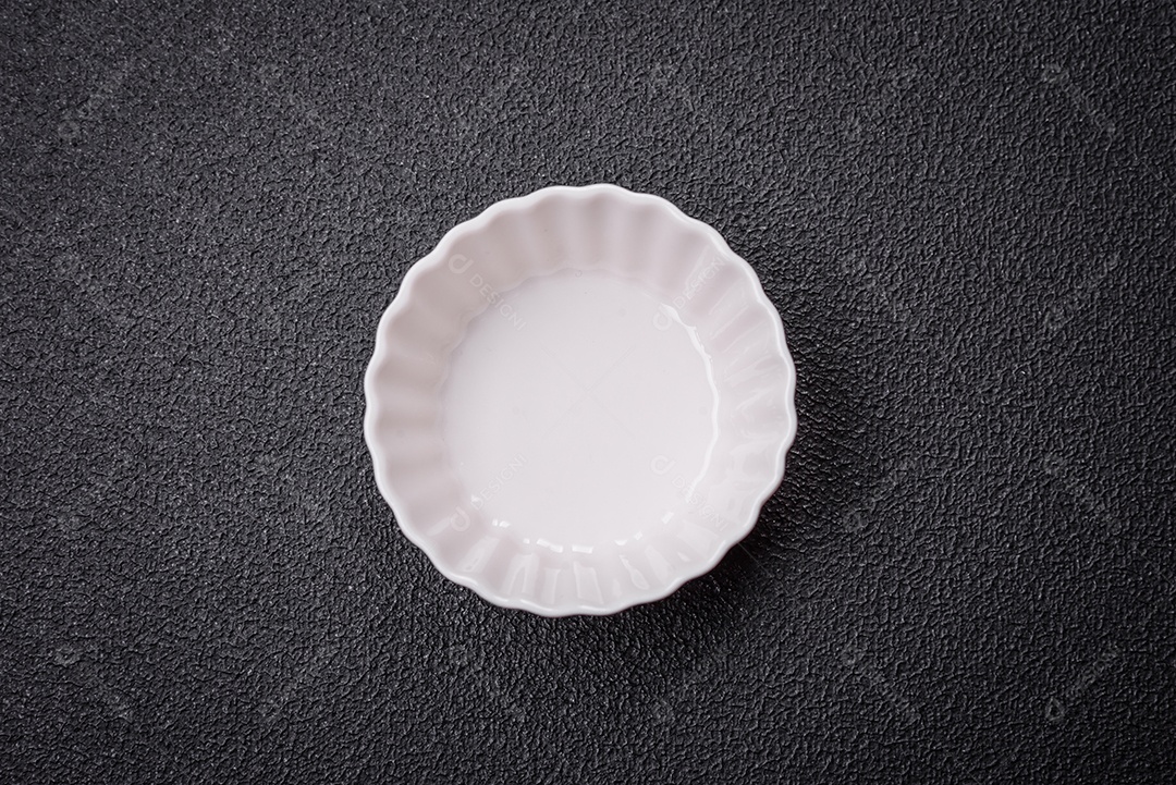 Linda molheira de cerâmica branca vazia em um fundo de concreto texturizado. Utensílio de cozinha