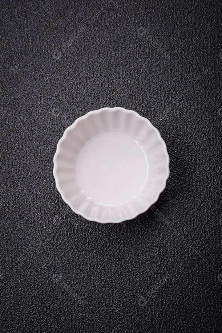 Linda molheira de cerâmica branca vazia em um fundo de concreto texturizado. Utensílio de cozinha