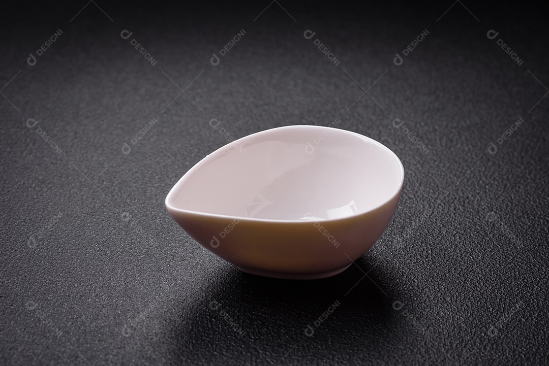 Linda molheira de cerâmica branca vazia em um fundo de concreto texturizado. Utensílio de cozinha