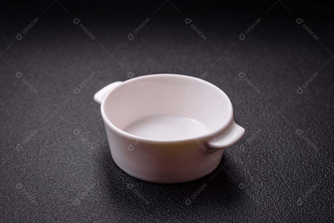 Linda molheira de cerâmica branca vazia em um fundo de concreto texturizado. Utensílio de cozinha