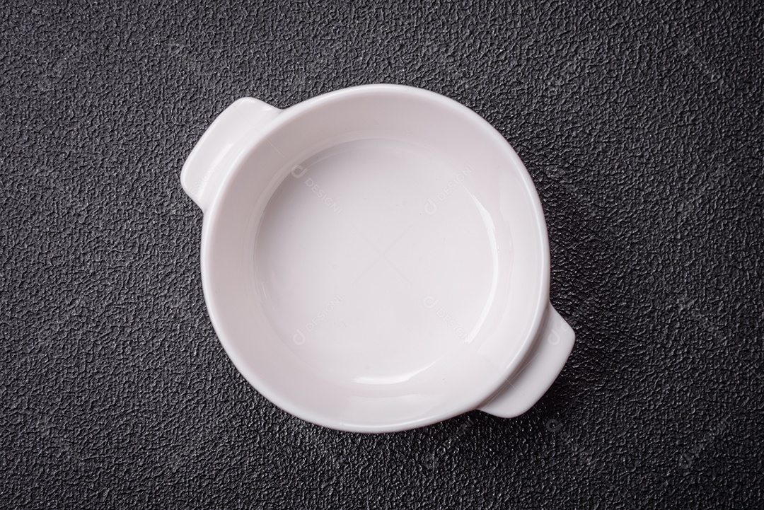 Linda molheira de cerâmica branca vazia em um fundo de concreto texturizado. Utensílio de cozinha