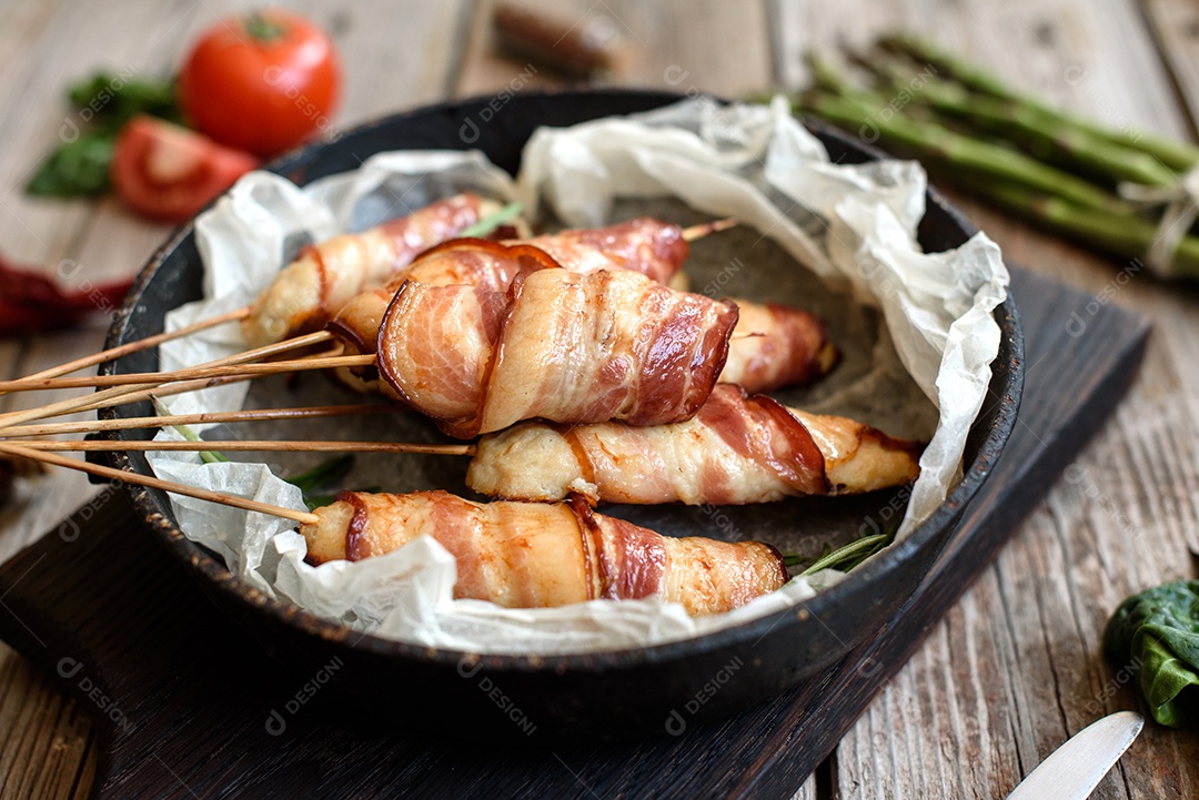 Espetinho rolo com bacon sobre mesa fundo isolado