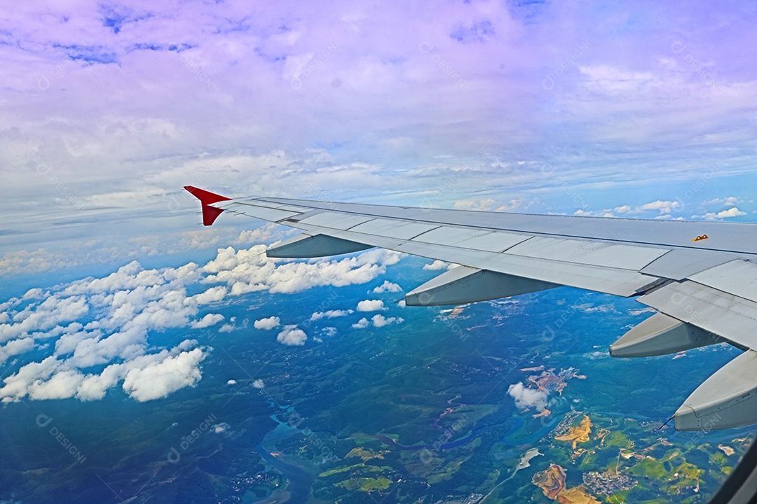 Asa de um avião voando acima da cidade A vista de uma janela de avião. Céu nublado e colorido com luz solar