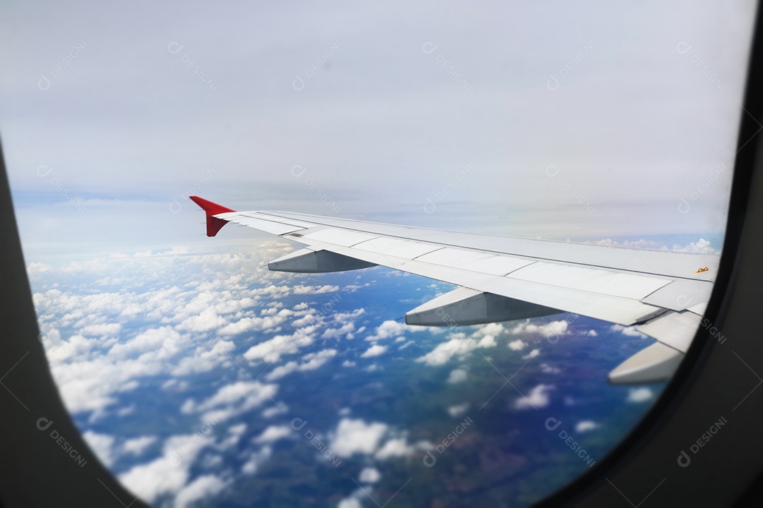 Asa de um avião voando acima da cidade A vista de uma janela de avião. Céu nublado e colorido com luz solar