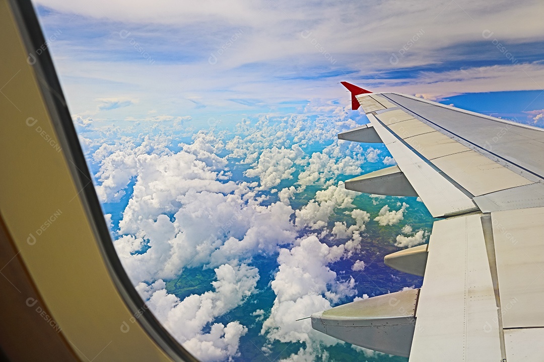 Asa de um avião voando acima da cidade A vista de uma janela de avião. Céu nublado e colorido com luz solar