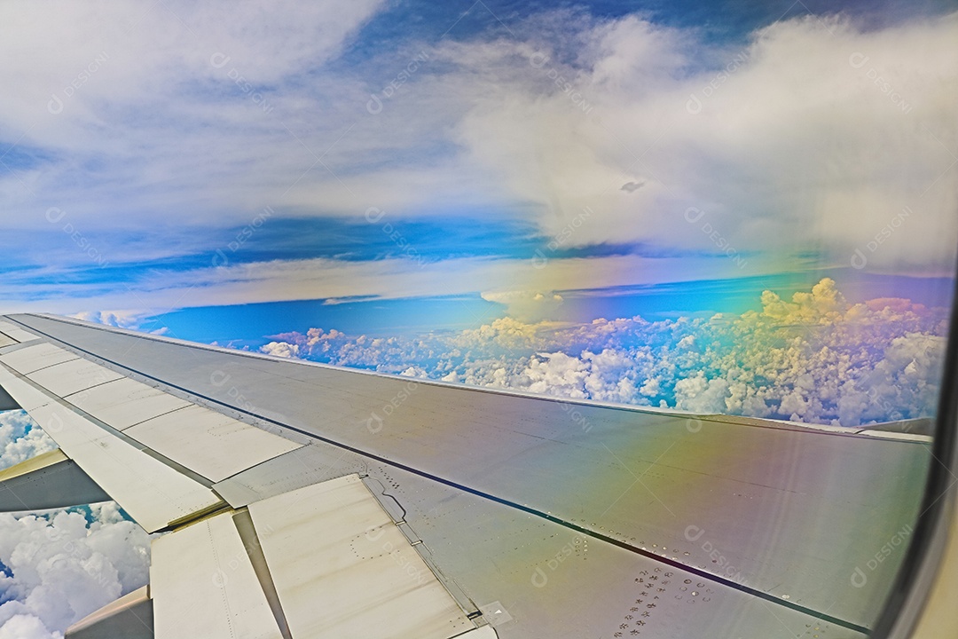 Asa de um avião voando acima da cidade A vista de uma janela de avião. Céu nublado e colorido com luz solar