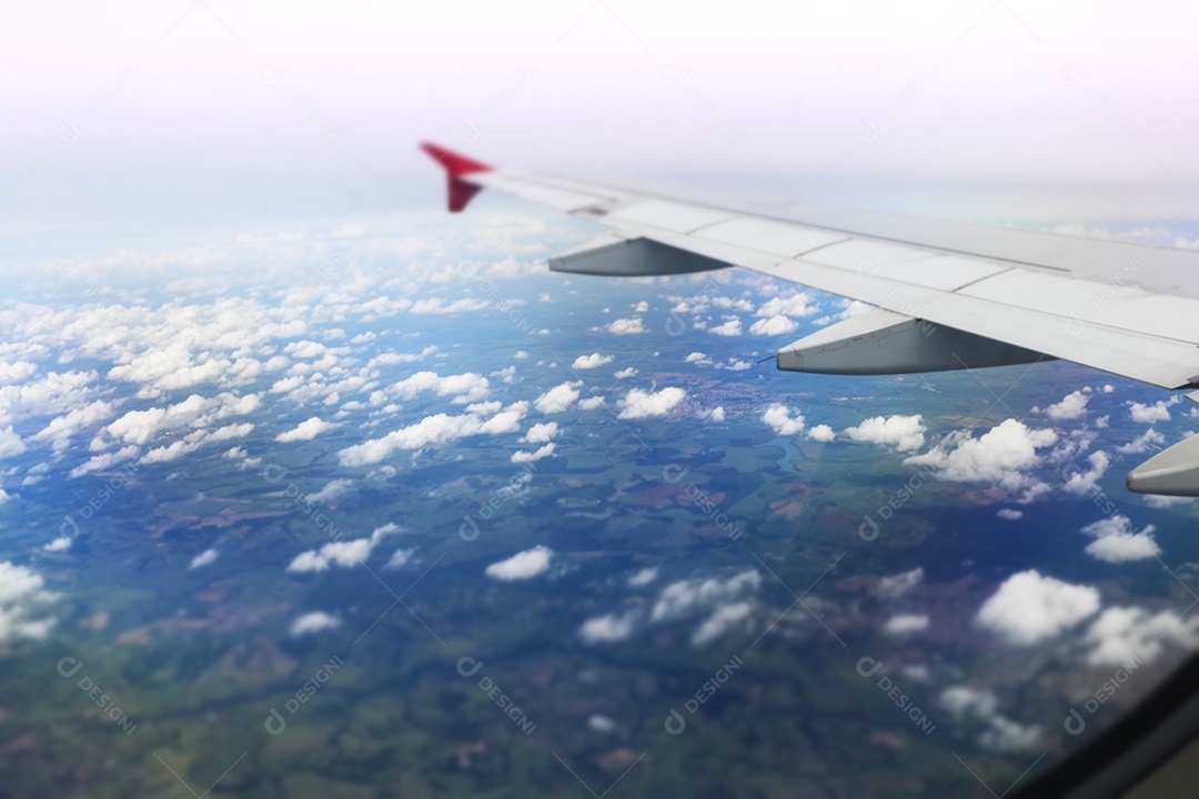 Asa de um avião voando acima da cidade A vista de uma janela de avião. Céu nublado e colorido com luz solar