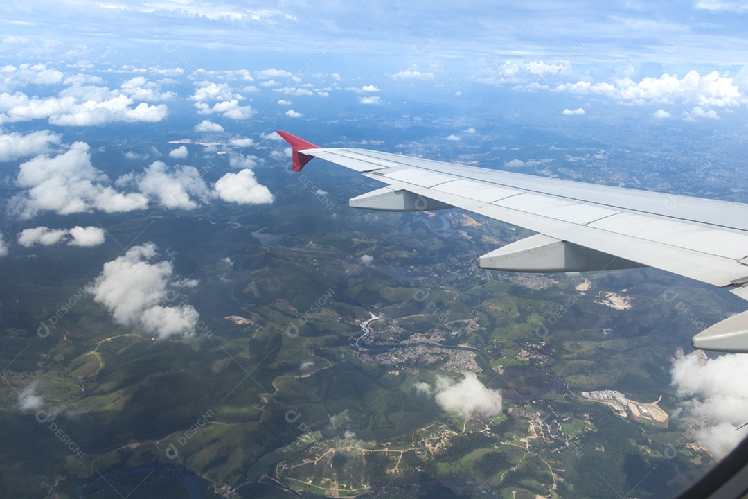 Asa de um avião sobrevoando uma cidade