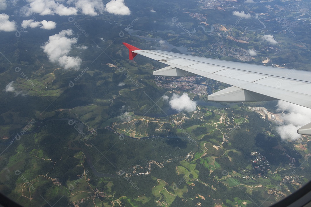 Asa de um avião sobrevoando uma cidade