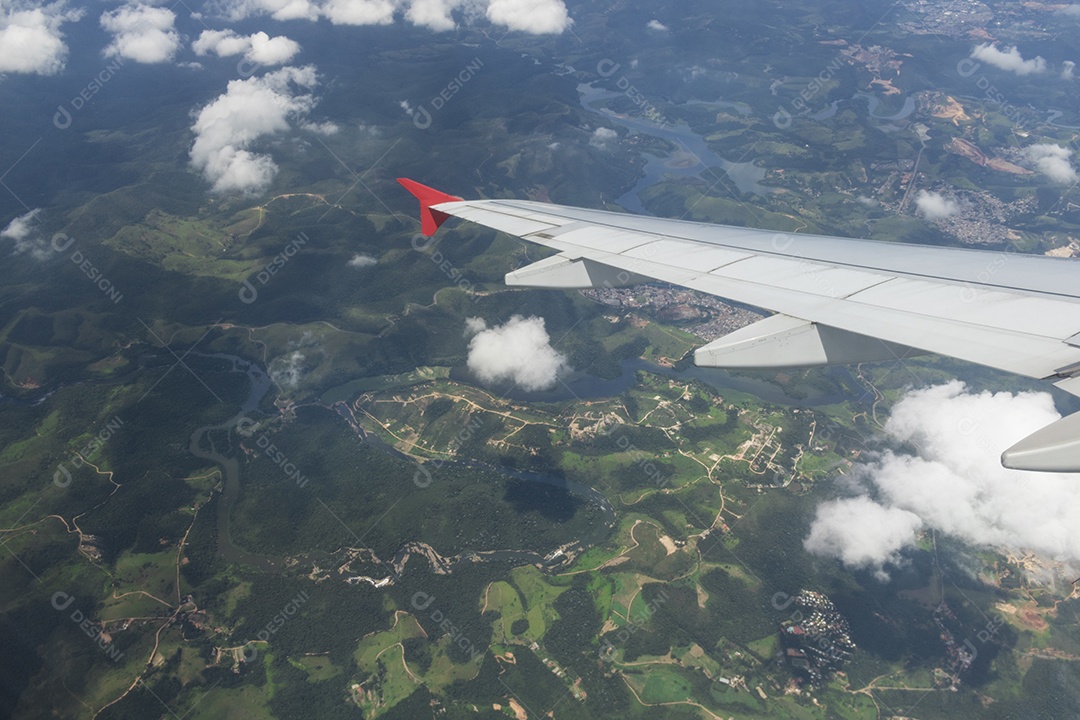 Asa de um avião sobrevoando uma cidade