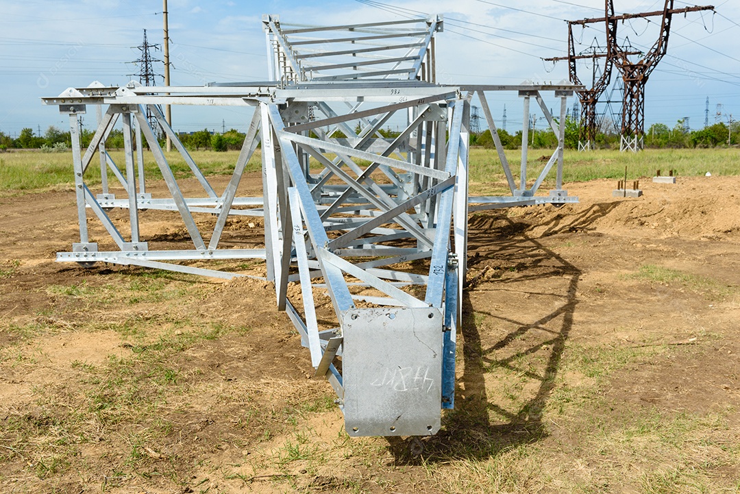 Instalação de coluna para linha elétrica de alta tensão contra o fundo do céu azul num dia ensolarado de verão