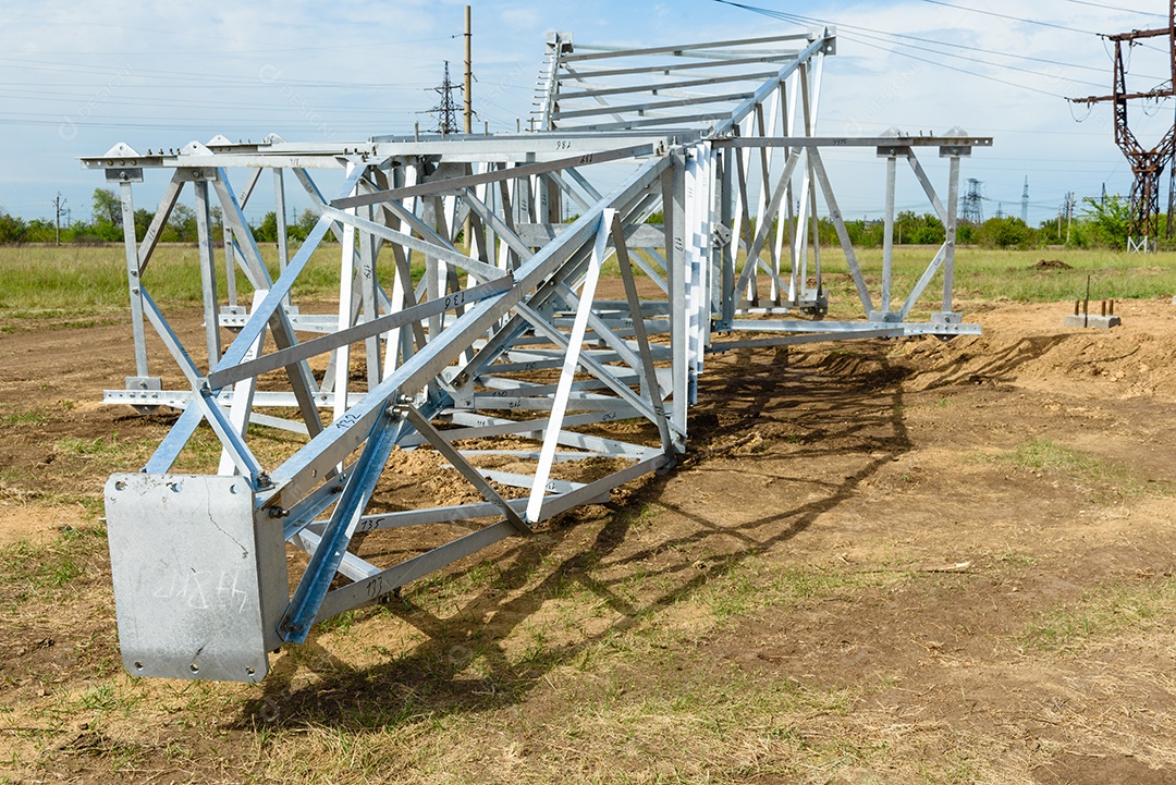 Instalação de coluna para linha elétrica de alta tensão contra o fundo do céu azul num dia ensolarado de verão