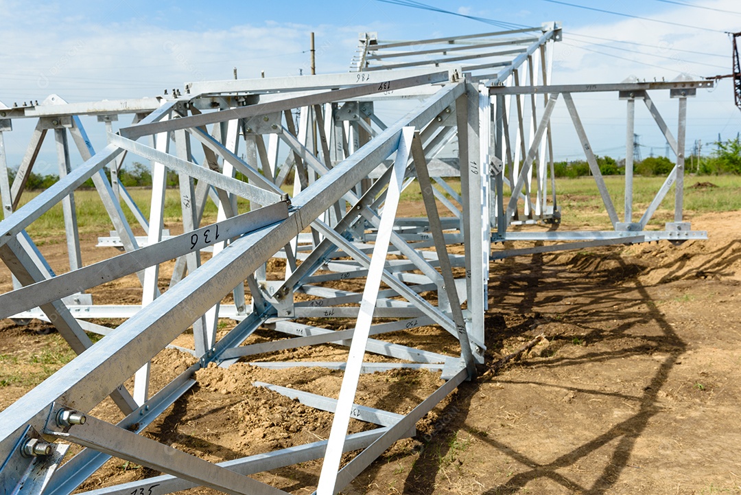 Instalação de coluna para linha elétrica de alta tensão contra o fundo do céu azul num dia ensolarado de verão