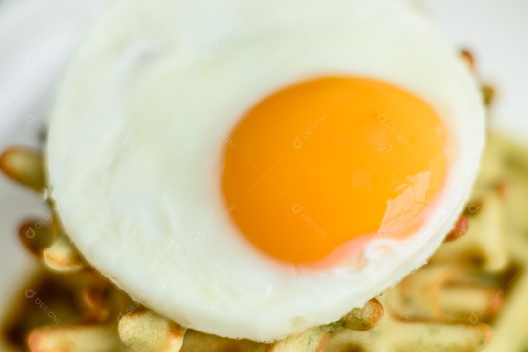 Pequeno-almoço fresco, delicioso e nutritivo com waffles com espinafre, ovo frito e pedaços de abacate
