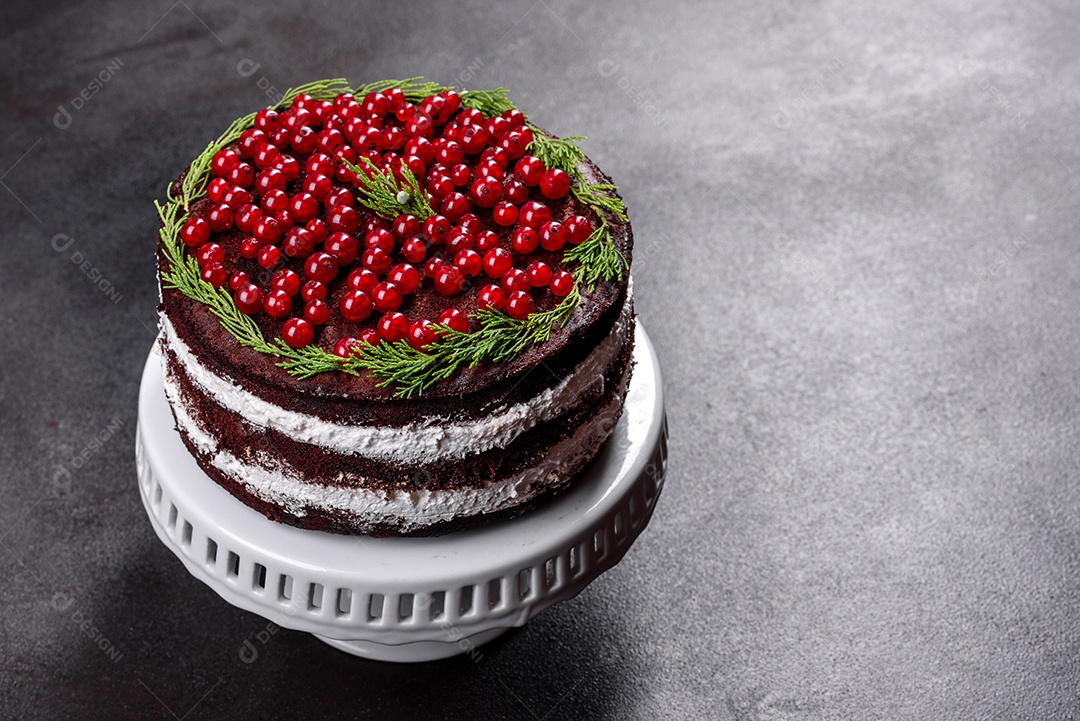 Lindo bolo delicioso com frutas vermelhas brilhantes na mesa de Natal