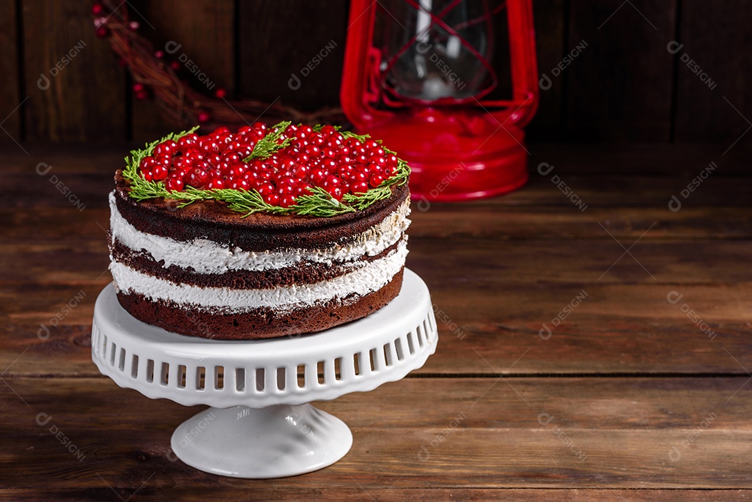 Lindo bolo delicioso com frutas vermelhas brilhantes na mesa de Natal