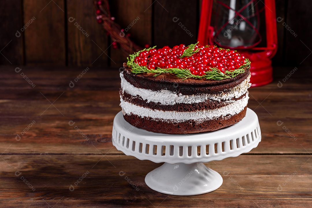 Lindo bolo delicioso com frutas vermelhas brilhantes na mesa de Natal