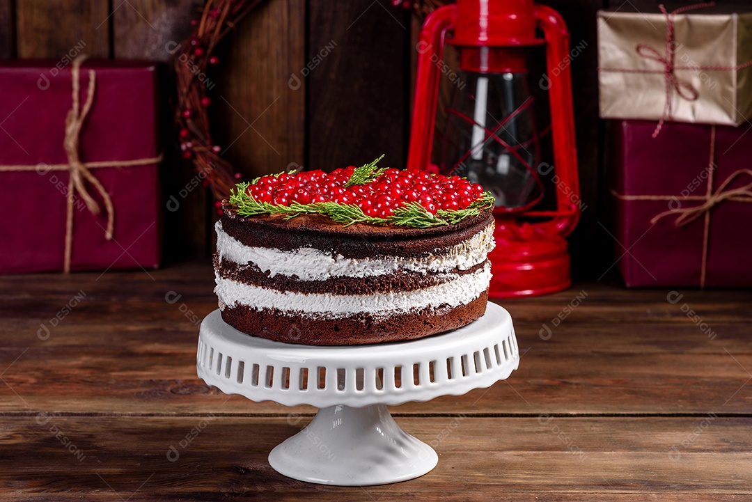 Lindo bolo delicioso com frutas vermelhas brilhantes na mesa de Natal
