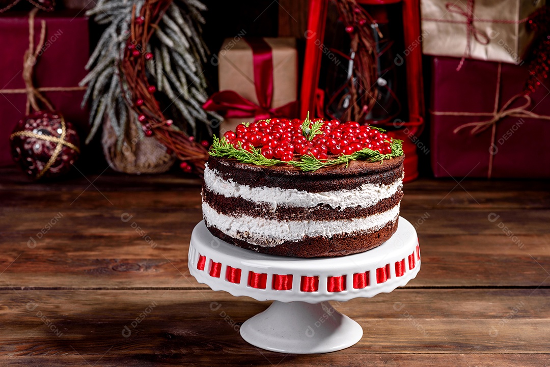 Lindo bolo delicioso com frutas vermelhas brilhantes na mesa de Natal