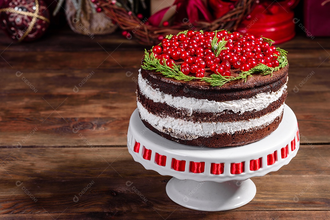 Lindo bolo delicioso com frutas vermelhas brilhantes na mesa de Natal