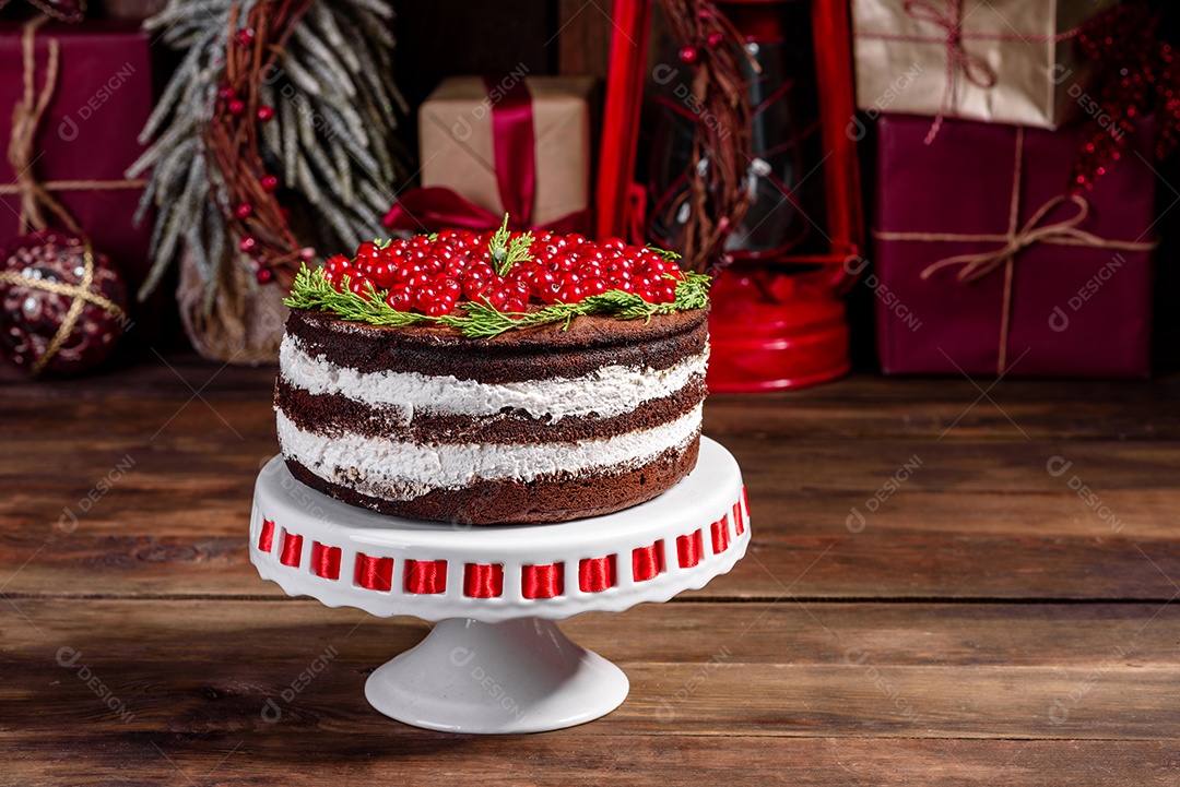 Lindo bolo delicioso com frutas vermelhas brilhantes na mesa de Natal