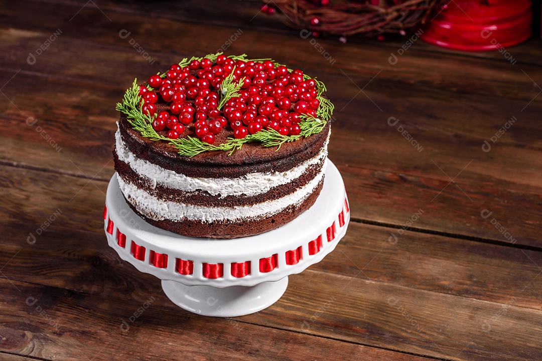 Lindo bolo delicioso com frutas vermelhas brilhantes na mesa de Natal