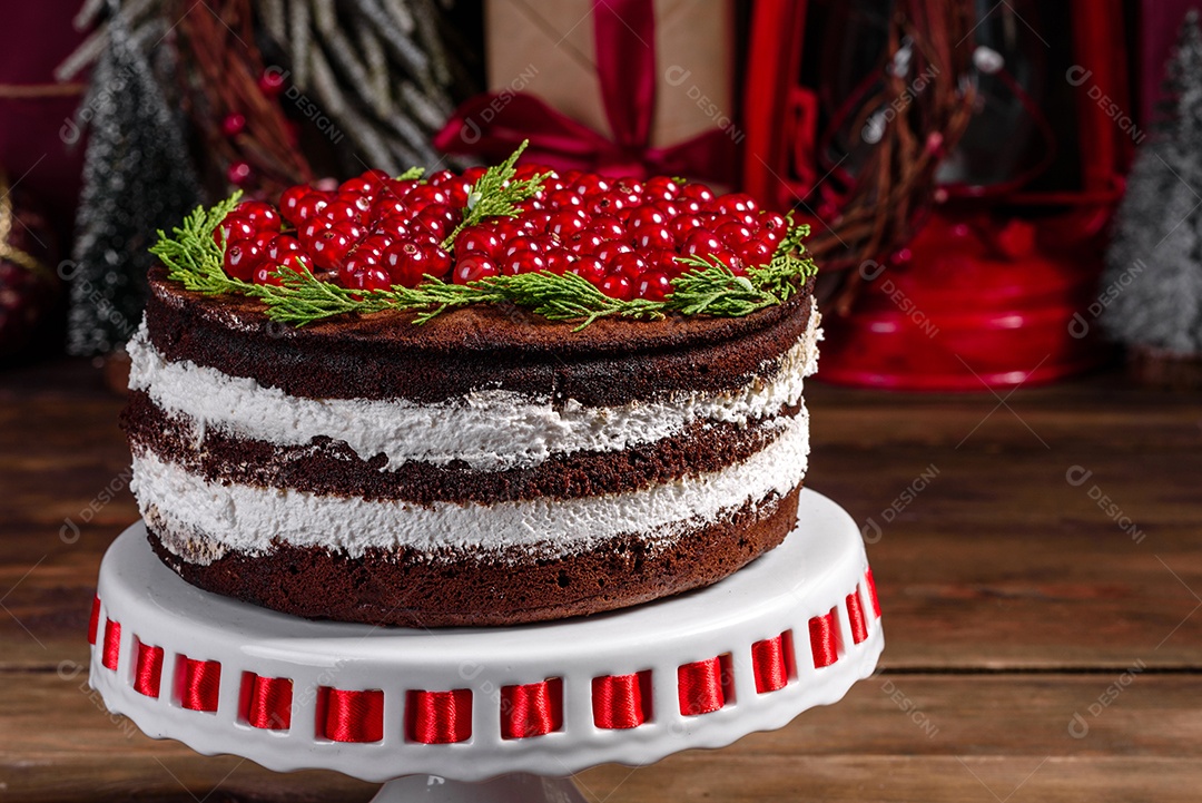 Lindo bolo delicioso com frutas vermelhas brilhantes na mesa de Natal