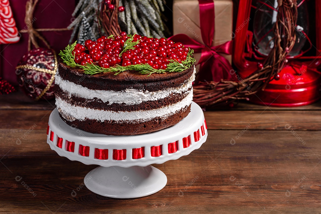 Lindo bolo delicioso com frutas vermelhas brilhantes na mesa de Natal