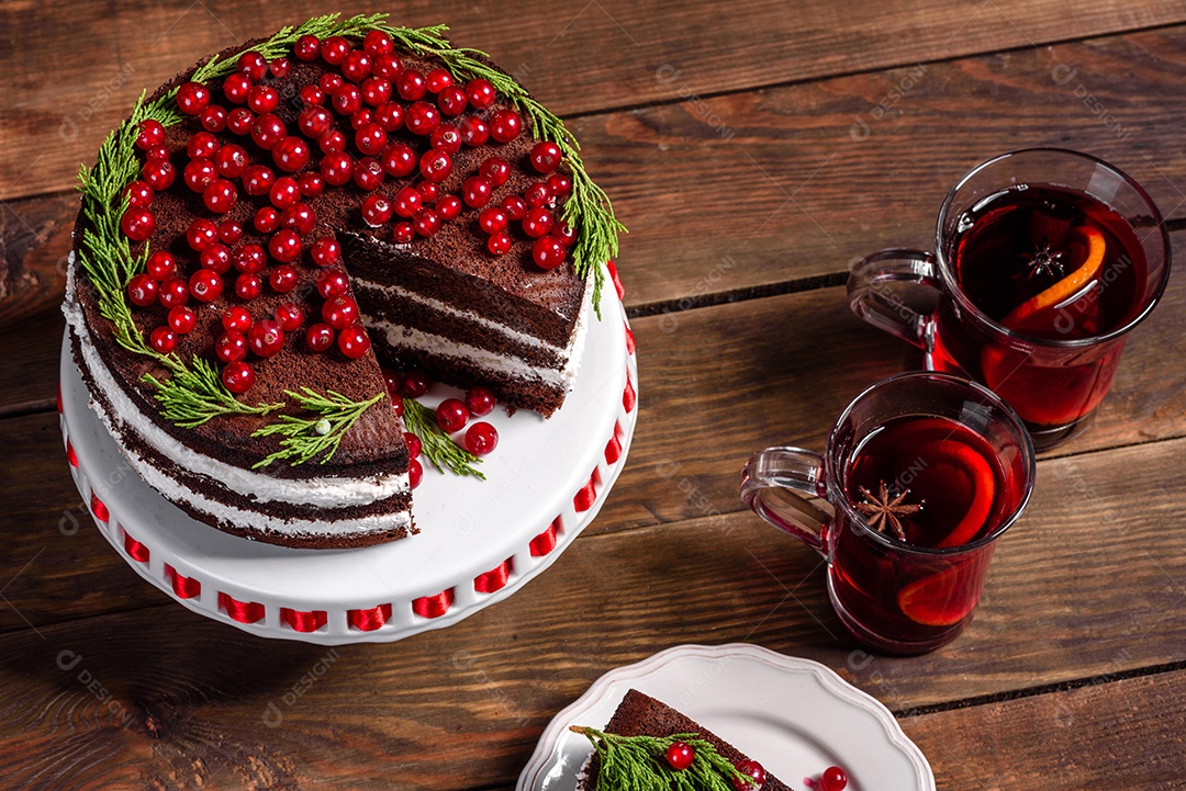 Lindo bolo delicioso com frutas vermelhas brilhantes na mesa de Natal com vinho quente perfumado com especiarias