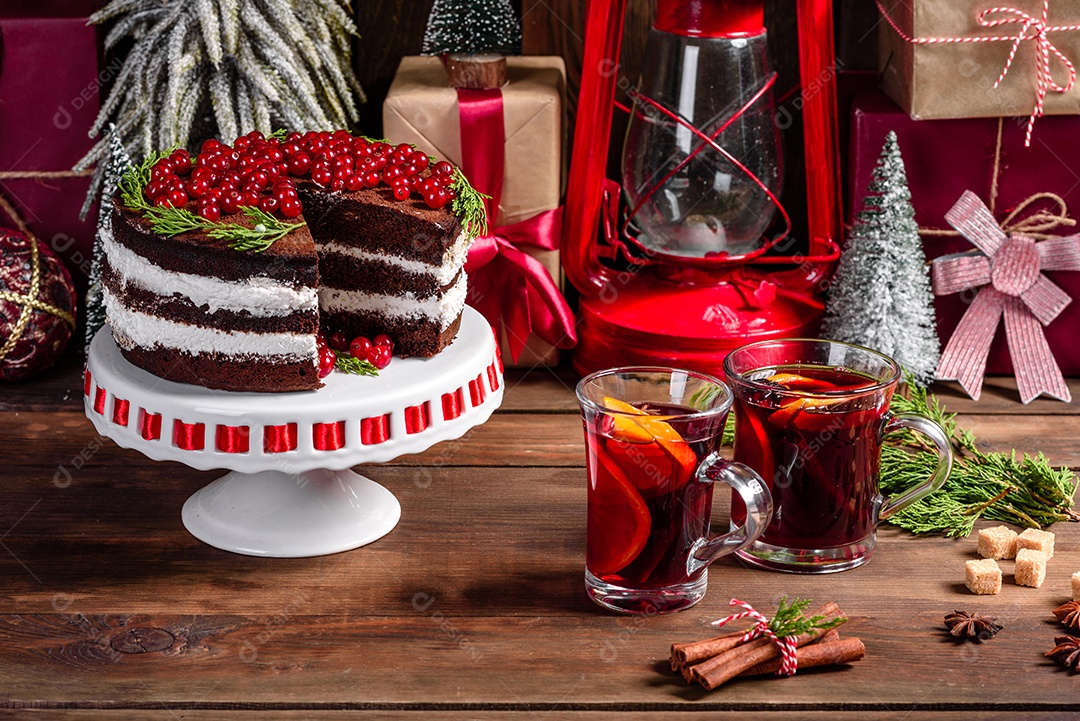 Lindo bolo delicioso com frutas vermelhas brilhantes na mesa de Natal com vinho quente perfumado com especiarias