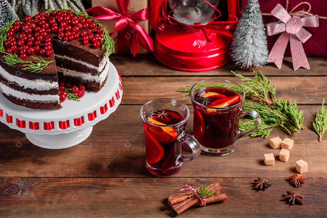 Lindo bolo delicioso com frutas vermelhas brilhantes na mesa de Natal com vinho quente perfumado com especiarias