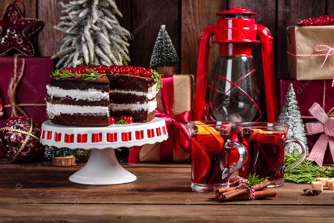 Lindo bolo delicioso com frutas vermelhas brilhantes na mesa de Natal com vinho quente perfumado com especiarias