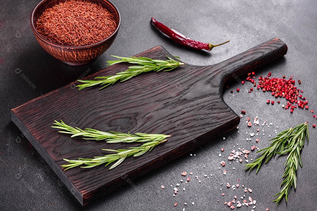 Composição de especiarias e ervas sobre fundo escuro de concreto como preparação para comida caseira