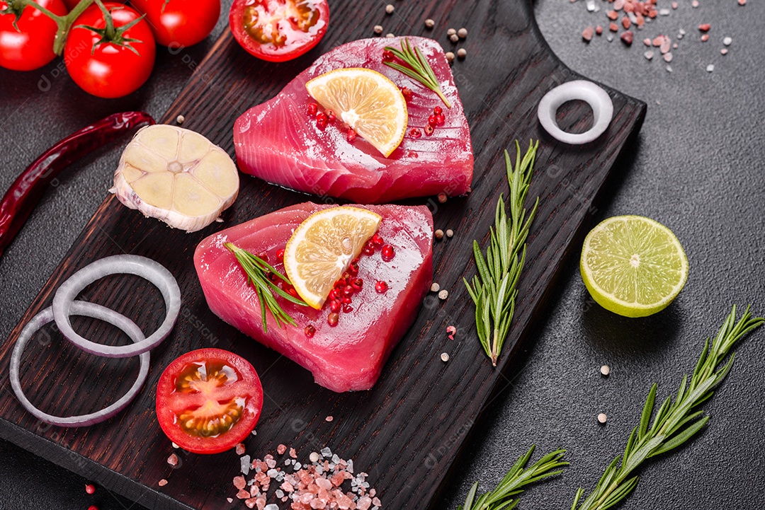 Bifes de filé de atum fresco com especiarias e ervas sobre fundo preto. Preparando atum para assar