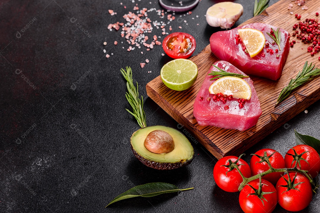 Bifes de filé de atum fresco com especiarias e ervas sobre fundo preto. Preparando atum para assar