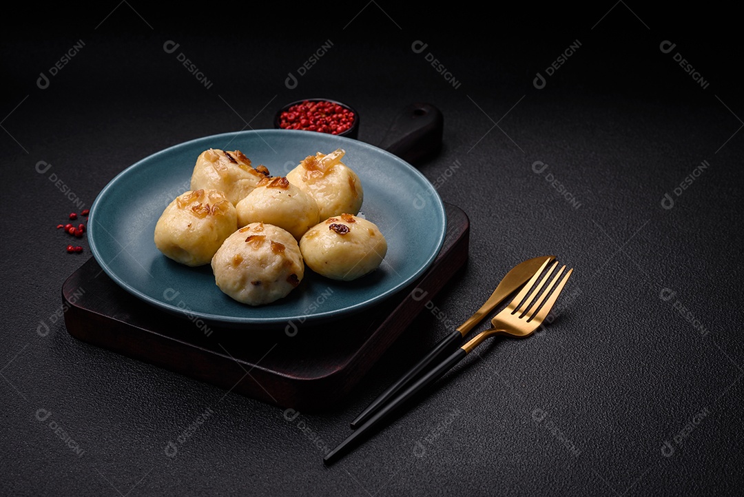 Deliciosos bolinhos caseiros cozidos frescos com queijo, batatas e sal num prato cerâmico